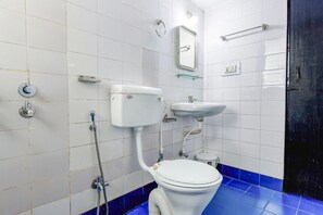 A bathroom with a toilet, sink, and shower. - Fabexpress Alor Holiday Resort (Calangute)