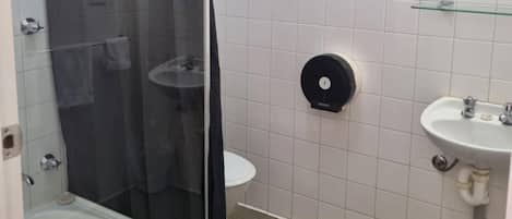 Une salle de bain avec une douche à parois de verre, un lavabo et des toilettes.