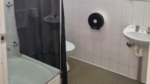 A bathroom with a glass-enclosed shower, a sink, and a toilet. - Blue Gums Hotel (Adelaide)