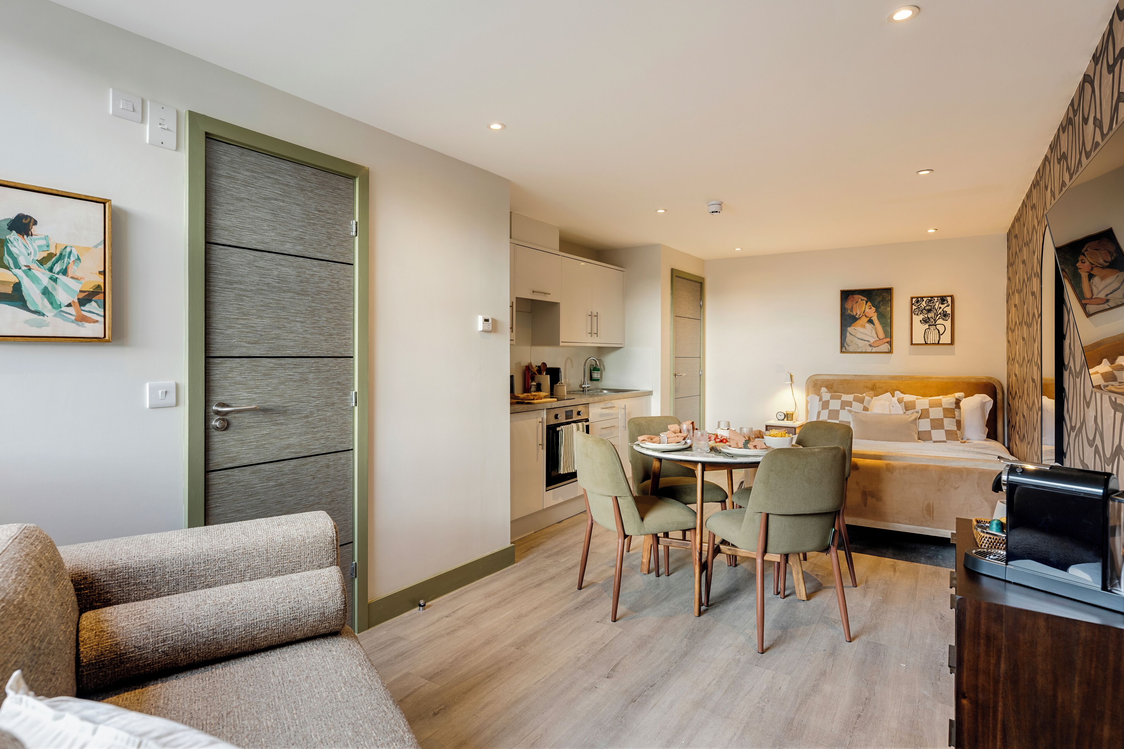 Un appartement moderne comprenant un coin repas, une cuisine et une chambre.
