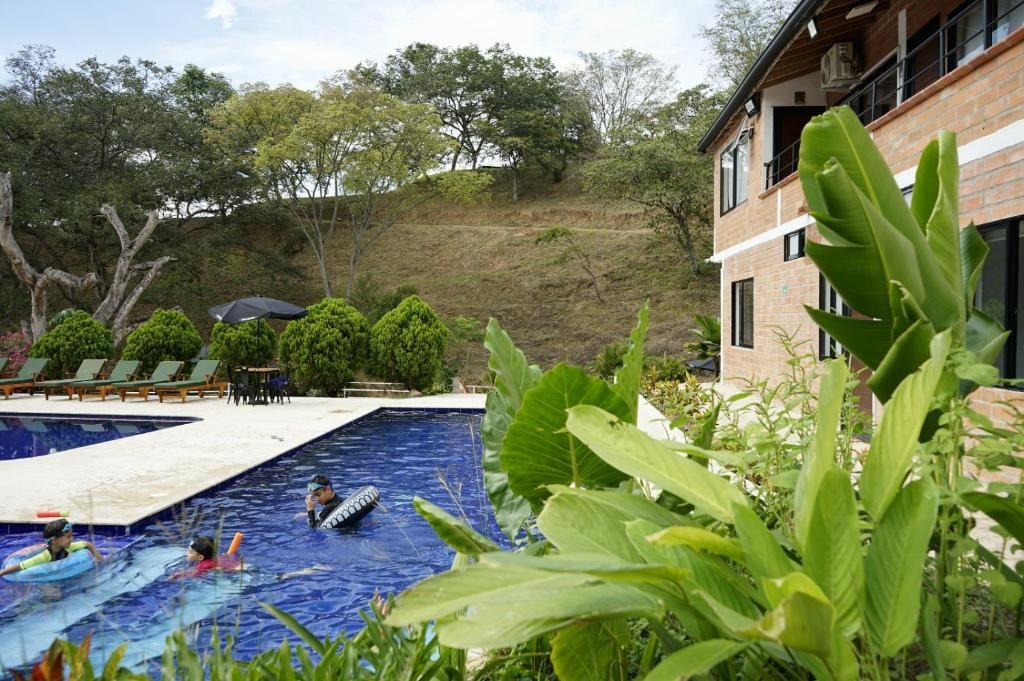 A swimming pool area with lounge chairs and a building in the background.