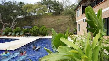 A swimming pool area with lounge chairs and a building in the background.