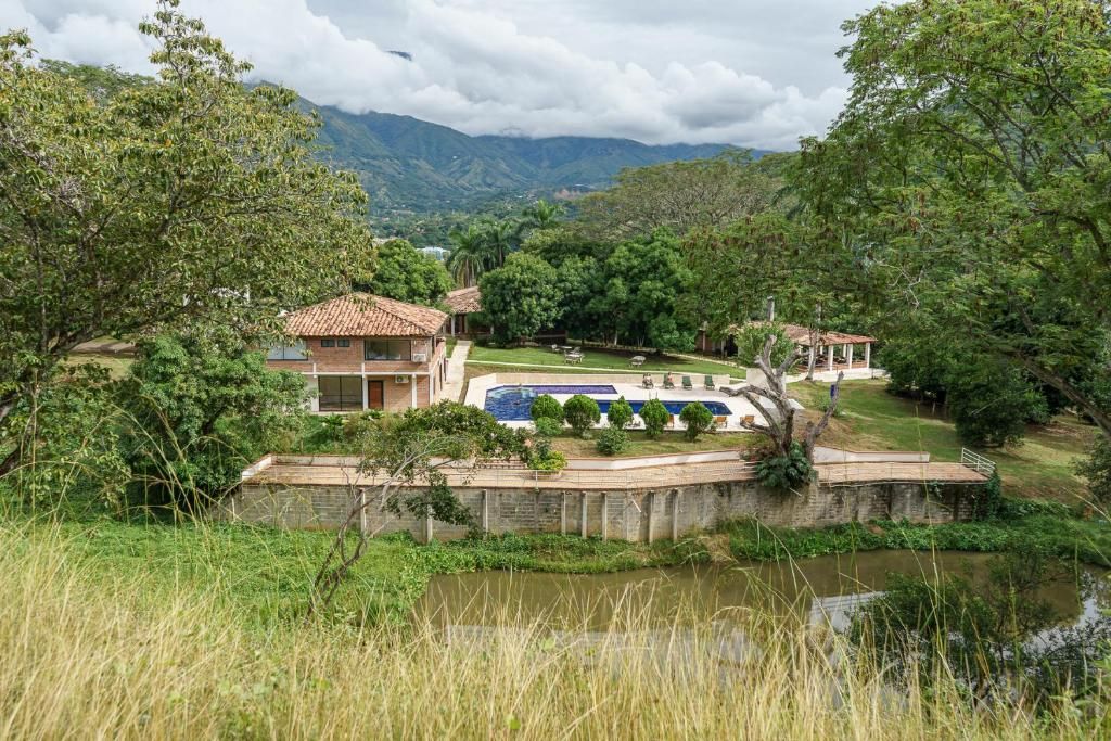 Una villa con piscina, immersa nel verde rigoglioso e con montagne sullo sfondo.
