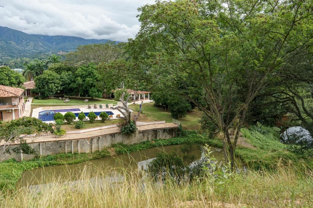 Ein Resort mit Swimmingpool, einer Brücke und Blick auf die umliegende Natur und Berge.