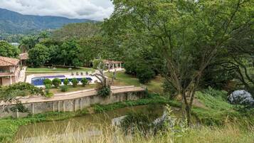 Ein Resort mit Swimmingpool, einer Brücke und Blick auf die umliegende Natur und Berge.