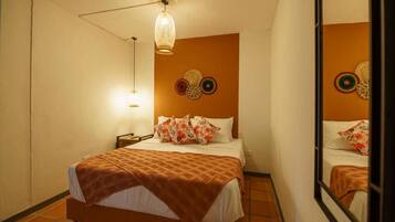 Una camera d'albergo con un letto, un comodino, una lampada e decorazioni murali.