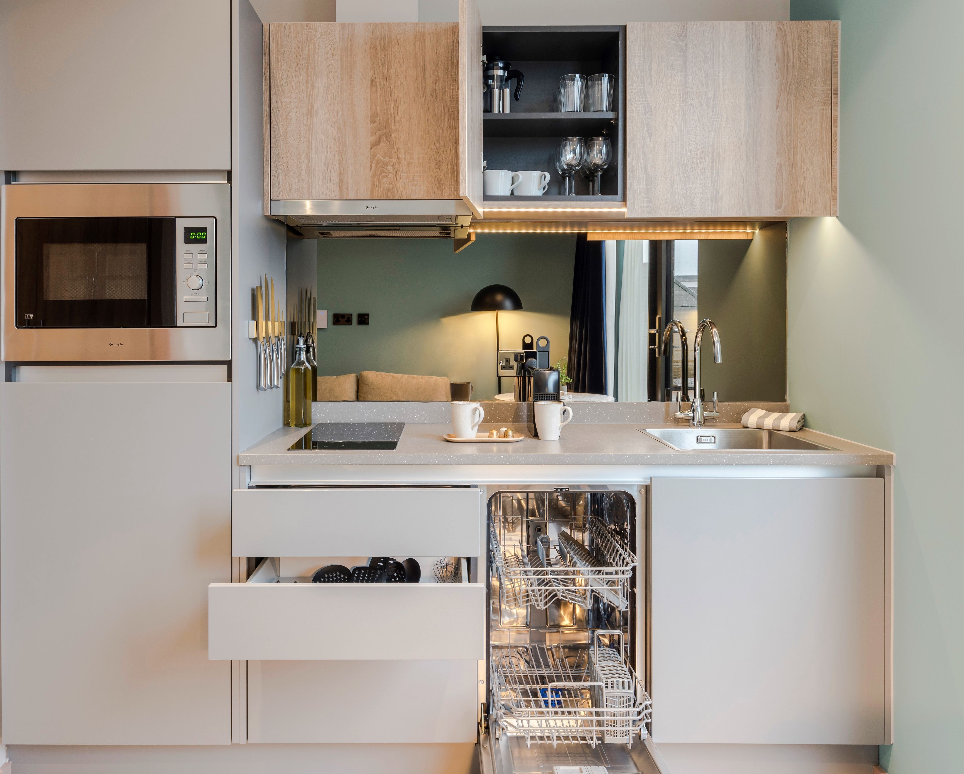 A compact kitchen with a microwave, a dishwasher, and a sink.
