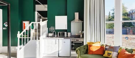 A modern kitchen with white cabinets, a built-in oven, and a refrigerator.