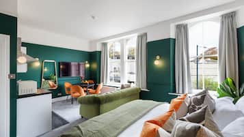 A hotel room with a bed, a desk, a chair, and a TV.