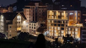Un hotel de varios pisos con un llamativo letrero de 'Radisson', que presenta una fachada moderna con ventanas grandes y una zona de balcón.