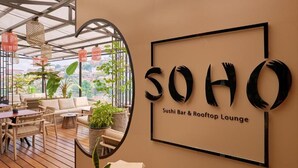 Un bar de sushi y un salón en la azotea con vistas a la ciudad.