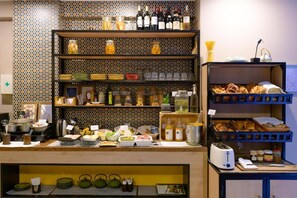 Un espace cuisine doté d’étagères remplies de divers produits alimentaires, d’ustensiles de cuisine et d’appareils électroménagers.