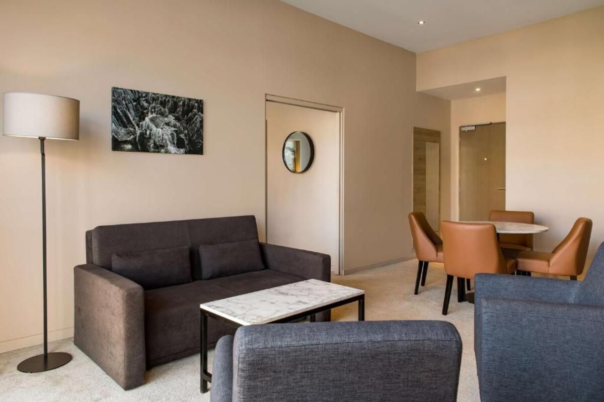 Un salon moderne comprenant un canapé, une table basse et un coin repas avec des chaises et une table.