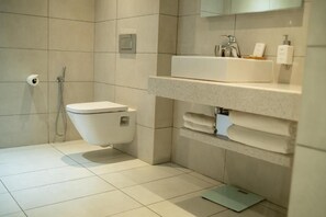 Une salle de bain moderne équipée de toilettes, d’un lavabo et d’une douche.