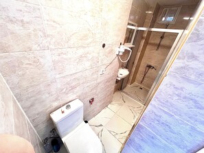 Ein Badezimmer mit Toilette, Waschbecken und Duschbereich.