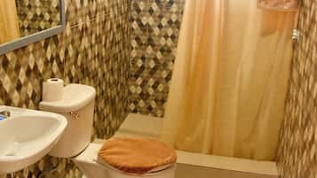 Een douche, handdoeken, zeep, toiletpapier