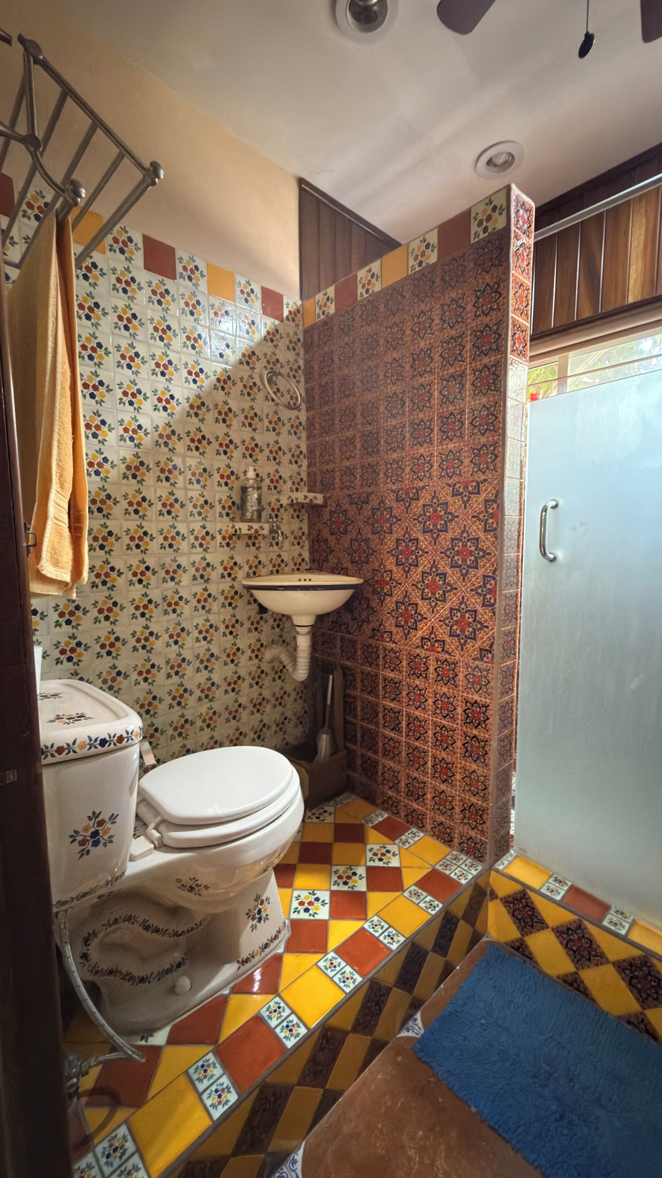 Un baño con inodoro, lavabo y zona de ducha.