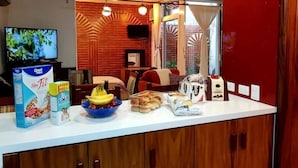 A kitchen with a white countertop, a television, and various food items. - Casa Primavera (Puerto Vallarta)