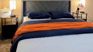 A hotel room with a bed, two framed artworks on the wall, a bedside lamp, and a small table with a plant. - 3-bedroom townhome in pleasant Mesquite with AC for relaxing stays (Mesquite)