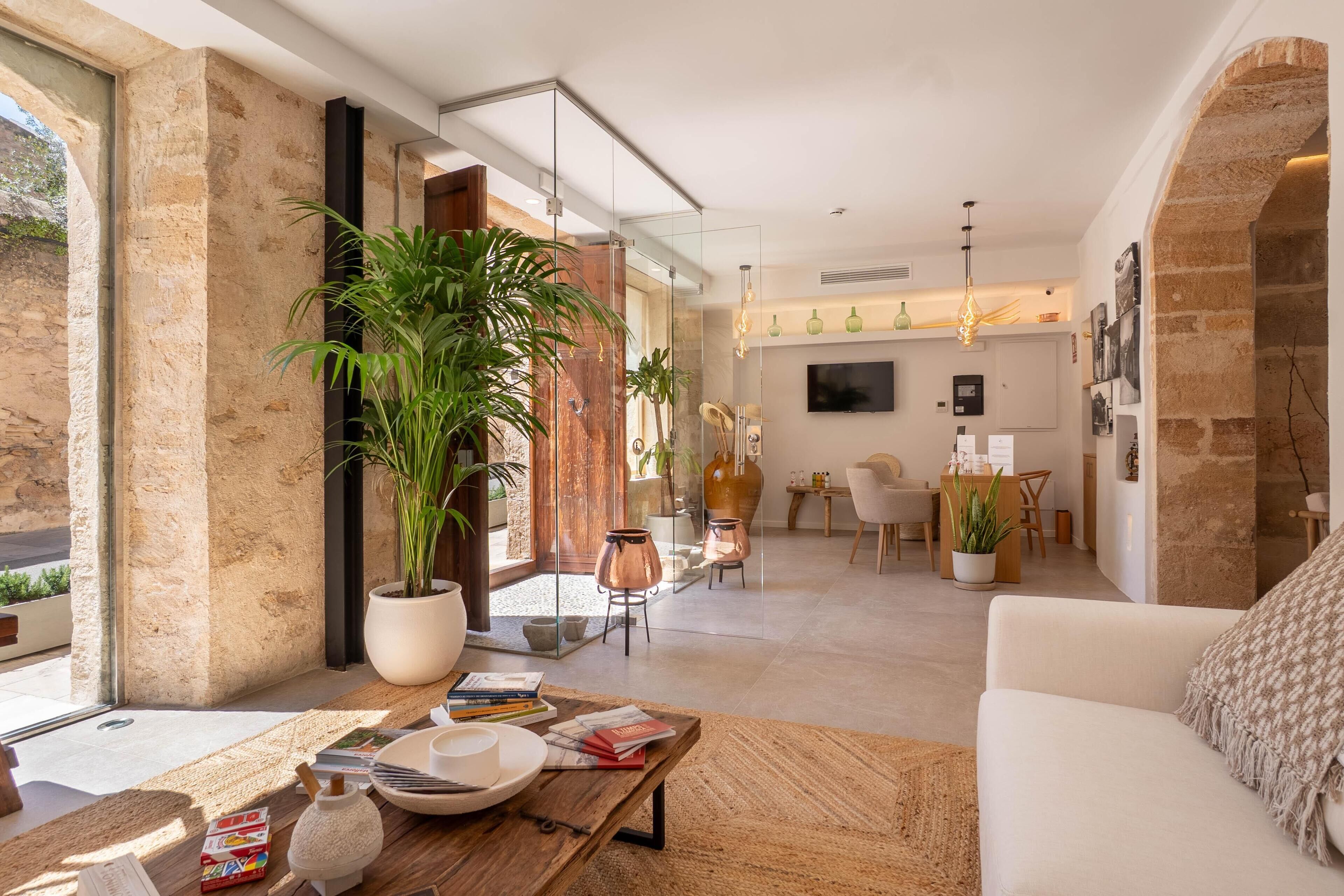 Una sala de estar moderna con un ventanal grande, una mesa de centro, un sofá y un comedor con sillas y una mesa.