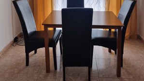 A dining area with a table and four chairs, a floor lamp, and curtains. - Happy House Central Apartment (Faro)