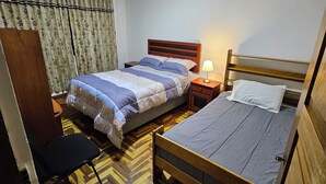 Une chambre avec deux lits, un bureau et une chaise.