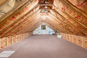 Ein Dachbodenraum mit Holzbalken und Isolierung.