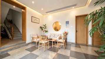 A modern interior with a checkered floor, wooden furniture, a staircase, and a door.