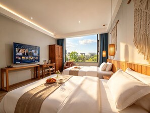 Habitación de hotel con dos camas, un escritorio, un televisor y vistas al exterior.