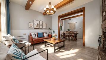 A modern living room with a sofa, coffee table, and artwork on the wall.