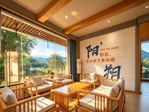 A modern interior with a wooden ceiling, a large window with a view of mountains, and a wall with Chinese characters. - Yangshuo Floral Whisper Valley (Guilin)