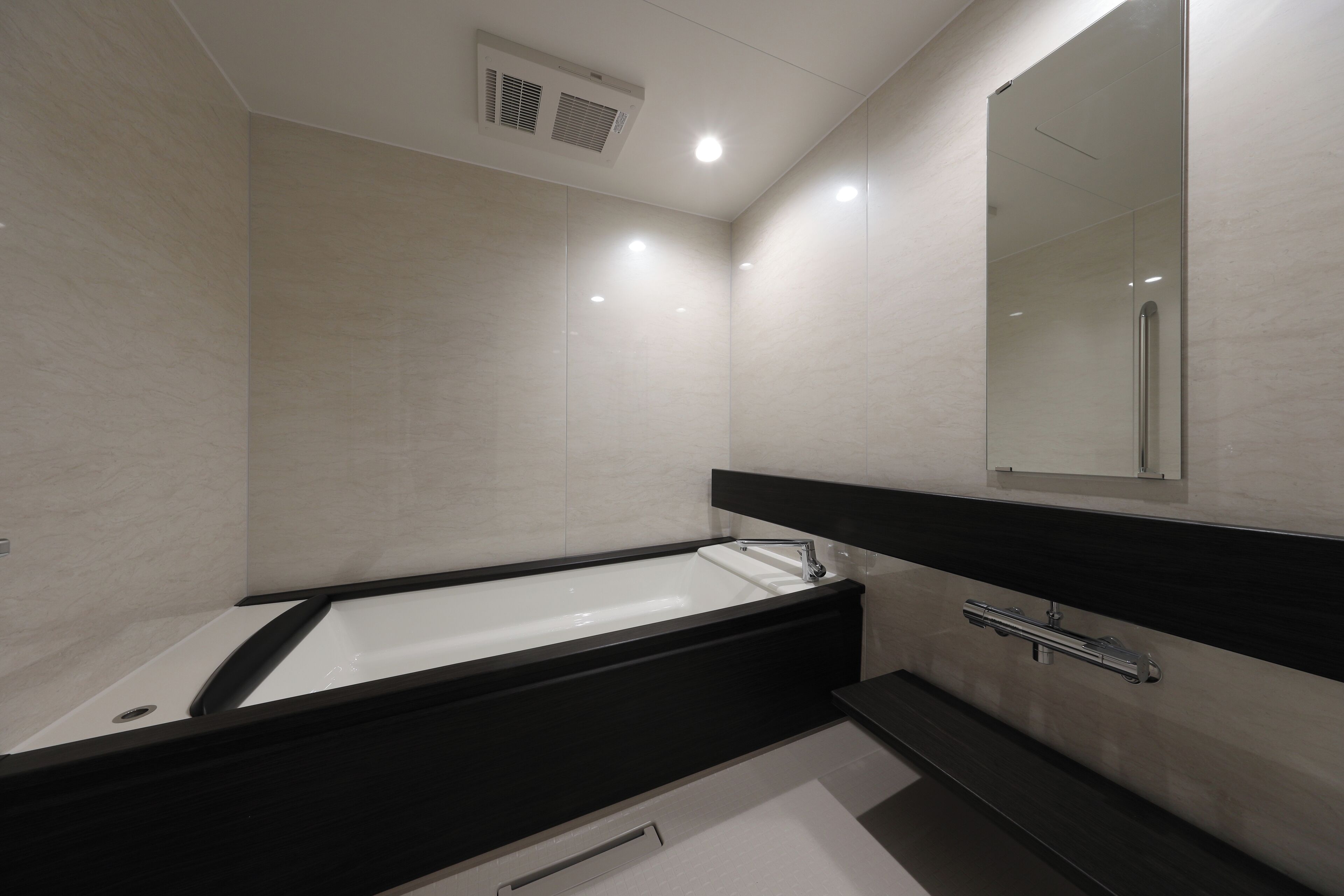 A modern bathroom with a bathtub, a mirror, and a shower.