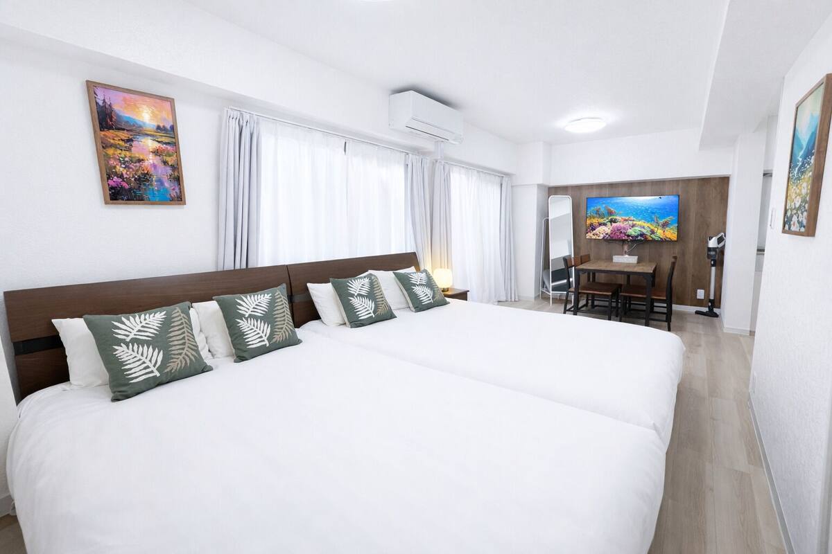 A hotel room with a large bed, a desk, and a chair.