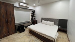 Una camera da letto con un letto, un armadio, una toeletta e un condizionatore d'aria.