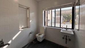 Un bagno piccolo e pulito, con il water, un lavandino e una doccia.