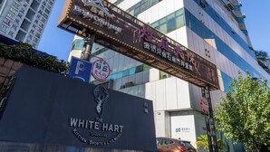 Un edificio de gran altura con un letrero que indica 'The White Hart' y 'Brightly' en la planta baja.