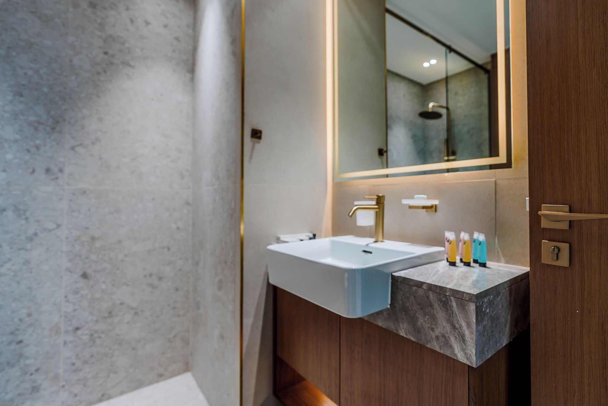 A modern bathroom with a dual sink vanity, a large mirror, and a wooden cabinet.