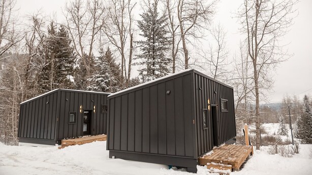 Two black metal cabins with a wooden deck, surrounded by snow-covered trees. - Tinwood Cabins The Descent, Cozy 3 min to Rossland (Rossland)