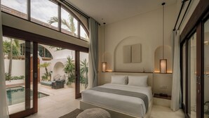 Ein modernes Schlafzimmer mit einem großen Bett, Blick auf einen Pool und einem Balkon.