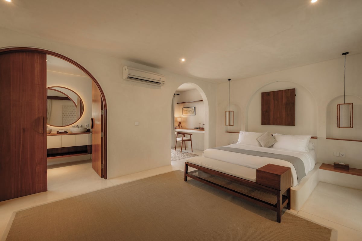 Une chambre à coucher avec un lit, une table de chevet et une armoire en bois.
