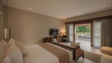 Habitación de hotel con una cama grande, un escritorio con silla, televisión y vistas al exterior.