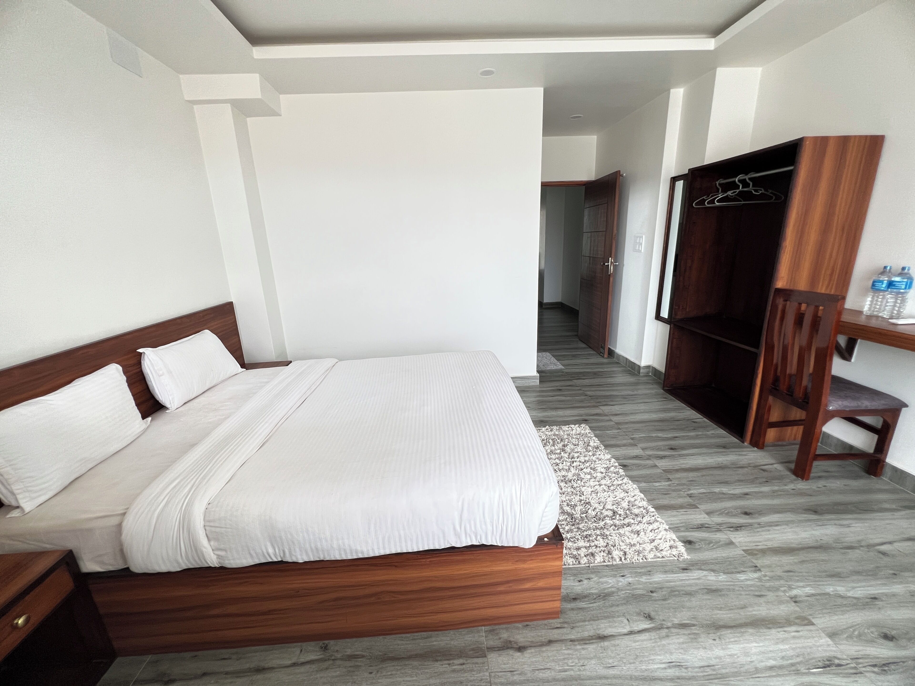 Ein Schlafzimmer mit einem hölzernen Bett, einem Kleiderschrank, einem Schreibtisch und einem Hängesessel.