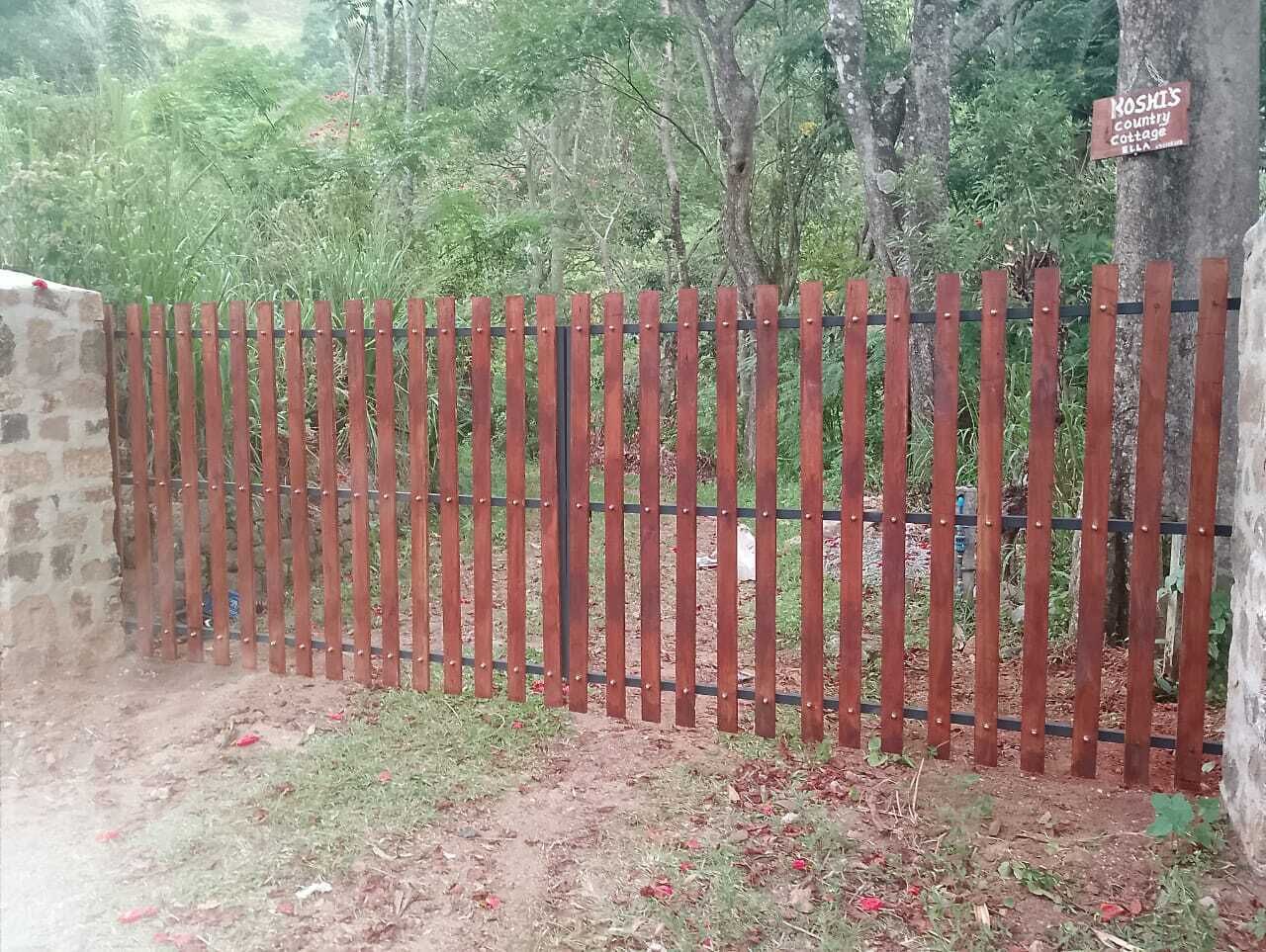 A wooden fence with a sign indicating 'Koska's Country Cottage'.