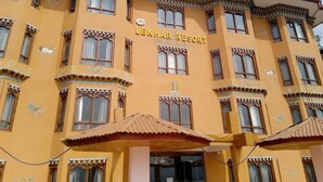 Un bâtiment portant l’enseigne « LEKHAR RESORT », ce qui indique qu’il s’agit d’un hôtel.