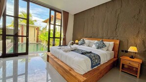 Quarto espaçoso com cama grande, mesa de cabeceira e vista para uma piscina e áreas verdes.