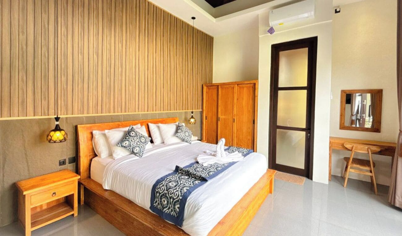 Une chambre à coucher moderne avec une tête de lit en bois, une armoire en bois, un bureau avec une chaise et une lampe de chevet.