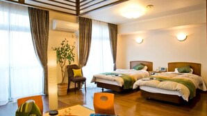 A hotel room with two beds, a dining table, a chair, a potted plant, and a wall-mounted air conditioner. - Senkei Plaza (Hakone)