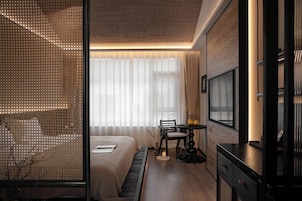 Una habitación de hotel moderna con cama, escritorio y televisión.