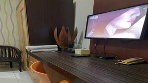 A room with a wooden desk, a television, and a chair. - Hotel Star 88 (Sleman)