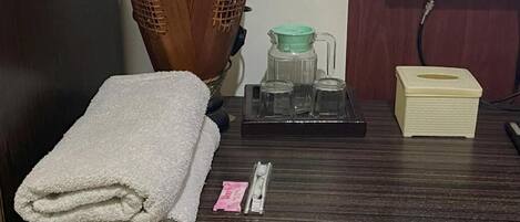 A neatly arranged bathroom with a towel, a tissue box, and a small bottle on the counter.